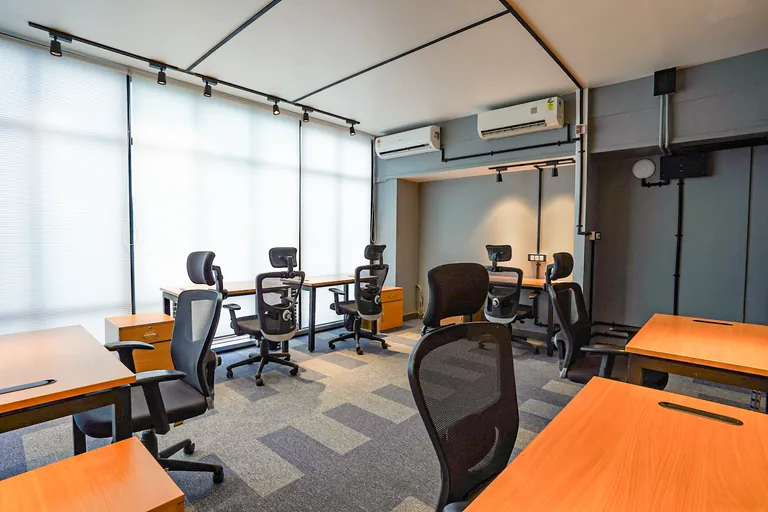 Shared desks beside the windows at Suits Mansarovar
