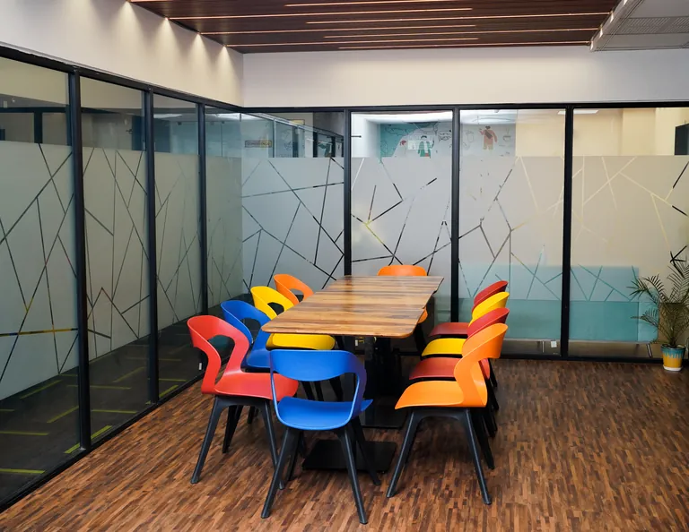Cafeteria table with colourful chairs at Suits Vaishali Nagar