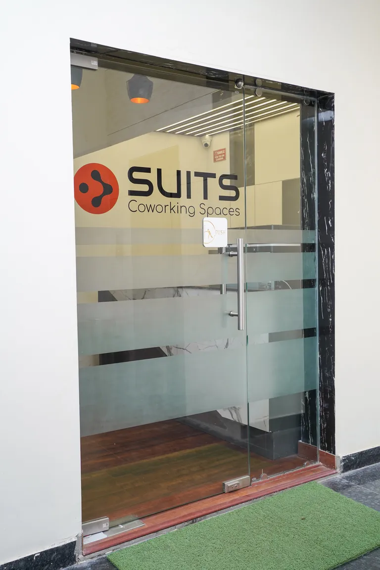 Glass entrance door with Suits signage at Suits Vaishali Nagar